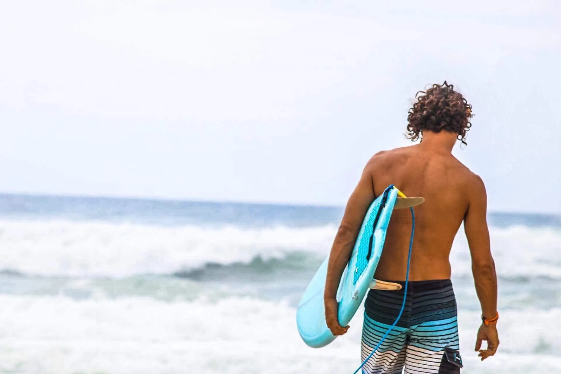 Marin, fondateur de Zourit École de Surf, observant l’océan à La Réunion.