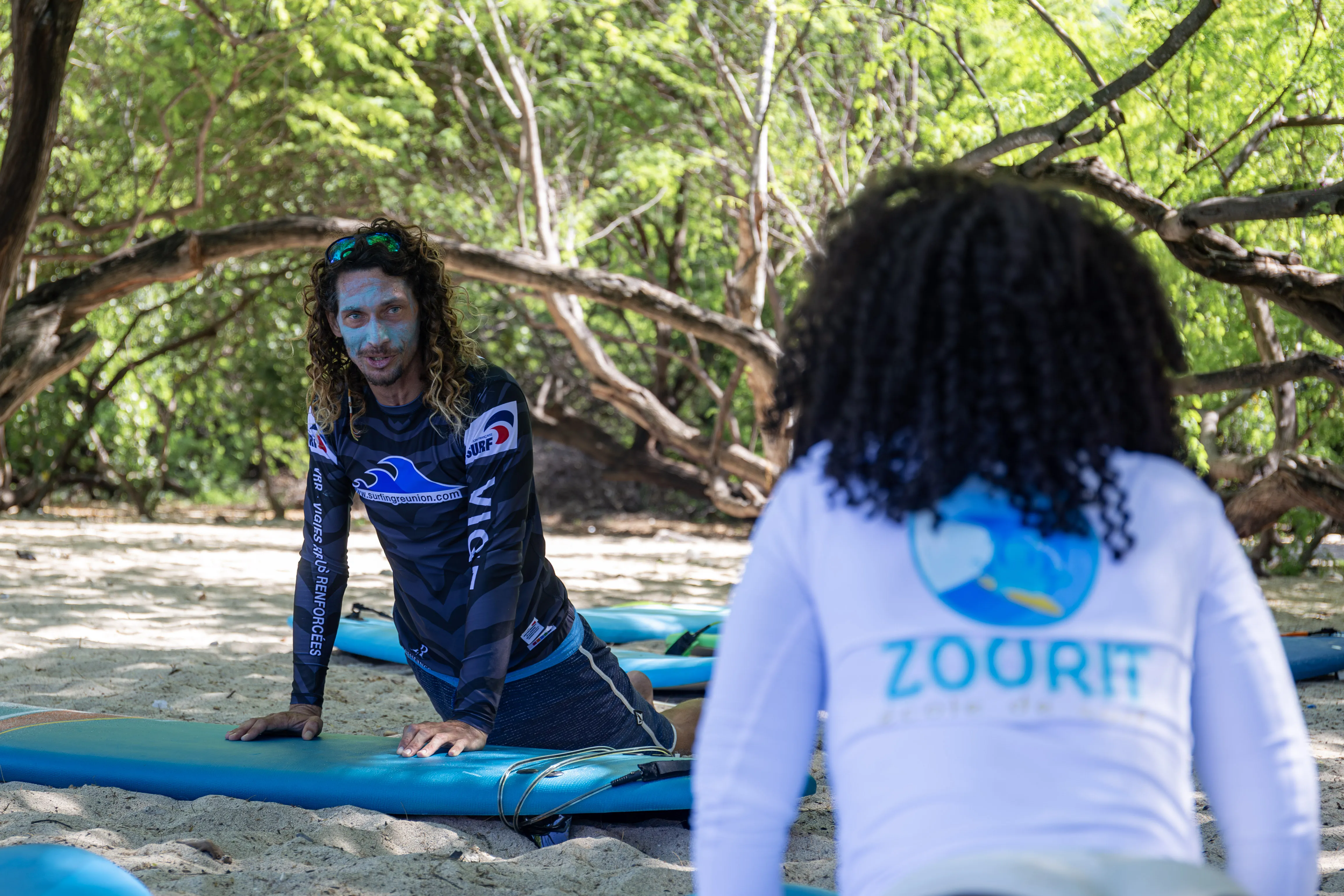 Moniteur de surf présentant le matériel utilisé lors des cours de surf à La Réunion.